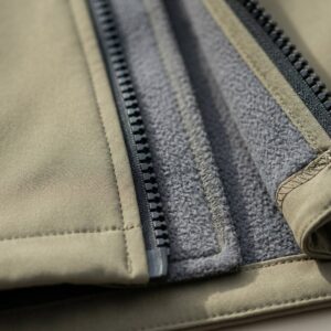 Softshell jacket zipper detail showing fleece-lined inner layer and flatlock stitching