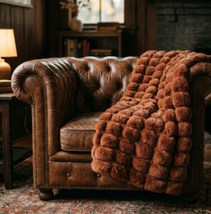 Custom terracotta bubble-ribbed faux fur throw blanket - draped on leather armchair, OEM wholesale manufacturer sample
